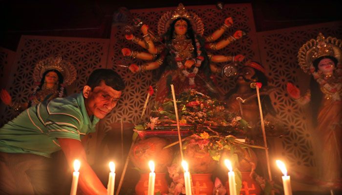 বিদ্যুৎ না থাকার কারণে পুরান ঢাকার তাঁতিবাজার এলাকায় মোমবাতি জ্বালিয়ে মণ্ডপ আলোকিত করার চেষ্টা।