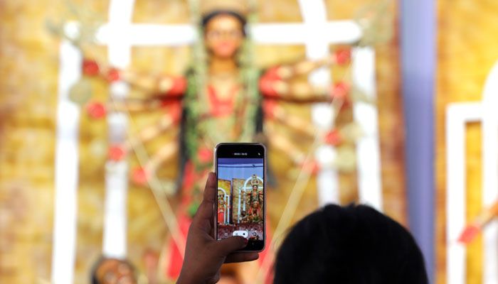পুরান ঢাকার শাঁখারী বাজারের প্রতিদ্বন্দ্বী পূজা কমিটিতে আসা ভক্তরা সেলফি তুলছে।