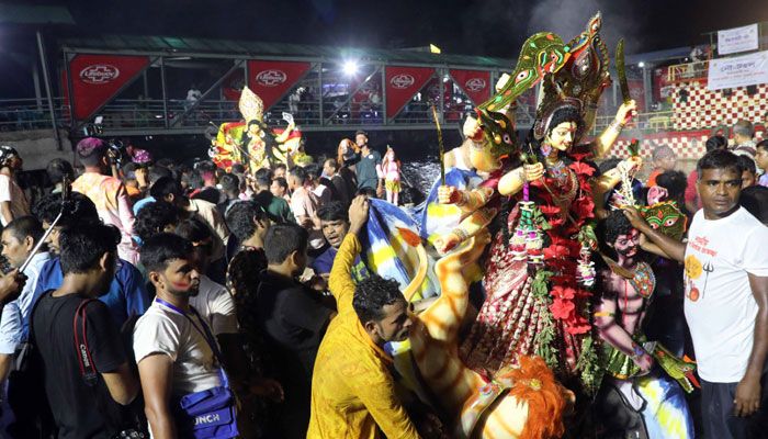 বিসর্জনের জন্য বুড়িগঙ্গা নদীতে নৌকা করে নিয়ে যাওয়া হচ্ছে। 