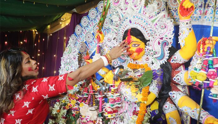 শাঁখারীবাজারে পূজামণ্ডপে দেবীকে বিদায়ের আগে সিঁদুর পরাচ্ছেন এক ভক্ত।