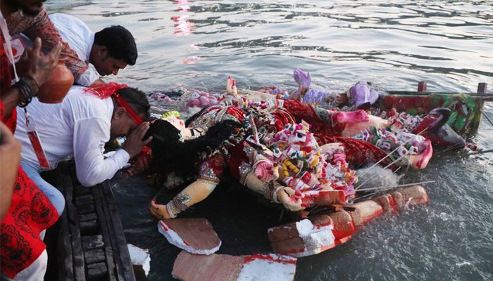 বুড়িগঙ্গা নদীতে দেবী দুর্গাকে বিসর্জনের পর প্রণাম করছেন এক ভক্ত। 