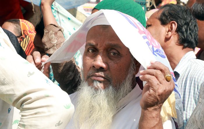  ওএমএসের ট্রাক থেকে পণ্য নিতে রোদে দাঁড়িয়ে ঘণ্টাার পর ঘণ্টা লাইনে দাঁড়িয়ে অপেক্ষা করছে মানুষজন। 