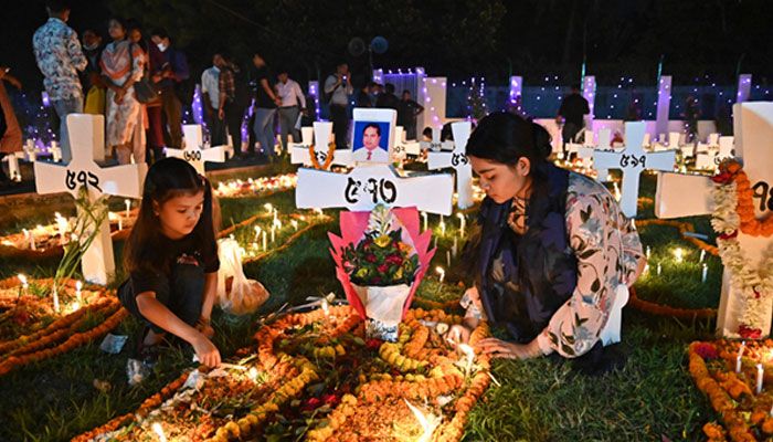 রাজধানীর তেজগাঁও গির্জায় বুধবার সন্ধ্যায় স্বজনের সমাধিতে ফুল দিচ্ছেন দু তরুণী। ছবি : আরিফুল আমিন