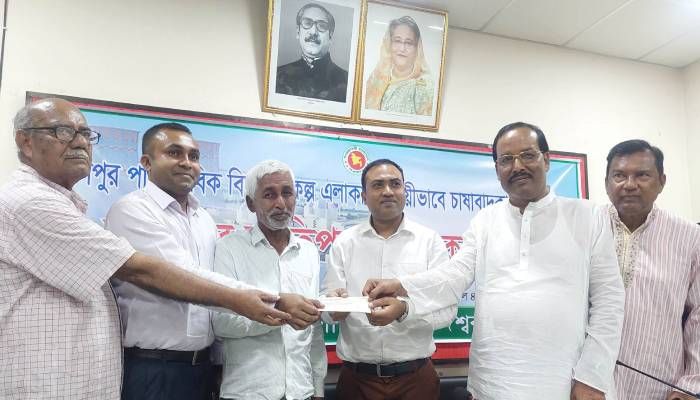কৃষক মহরম মিয়ার হাতে চেক তুলে দিচ্ছেন ইউএনও পিএম ইমরুল কায়েস। প্রবা ফটো