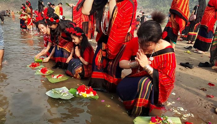নদীতে ফুল ভাসিয়ে পাহাড়ি তরুণীরা বৈসাবি উৎসবের সূচনা করেন। 
