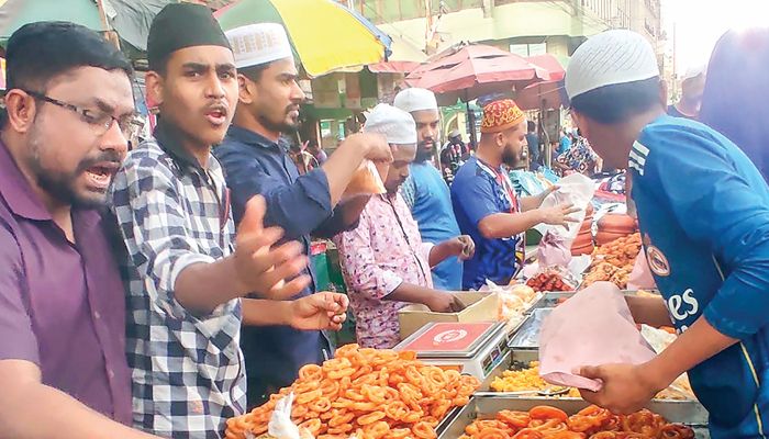 রাজধানীর কারওয়ান বাজারে ফুটপাতসহ নামিদামি হোটেলে বসে ইফতারি আয়োজন। বুধবার রাস্তার পাশের এক দোকান থেকে ক্রেতাদের আকর্ষণের চেষ্টায় কয়েক দোকানি। প্রবা ফটো