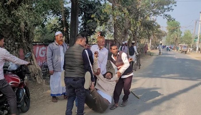 শেরপুরের ঝিনাইগাতীতে বুধবার নির্বাচনি ইশতেহার অনুষ্ঠানে বিএনপি ও জামায়াত নেতাকর্মীদের মধ্যে সংঘর্ষে আহত একজনকে হাসপাতালে নেওয়া হচ্ছে। ছবি: প্রতিদিনের বাংলাদেশ