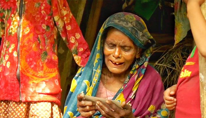 নিখোঁজ ছেলে ইউনূস সরকারের ছবি হাতে নিয়ে কাঁদছেন মা তারাবানু। ছবি: প্রতিদিনের বাংলাদেশ