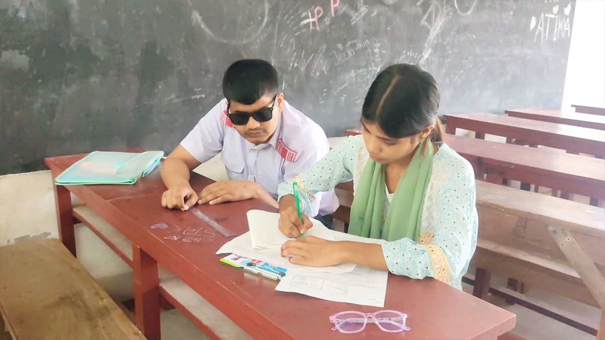 শ্রুতলেখকের সহায়তায় পরীক্ষা দিচ্ছেন দৃষ্টিপ্রতিবন্ধী শরিফ
