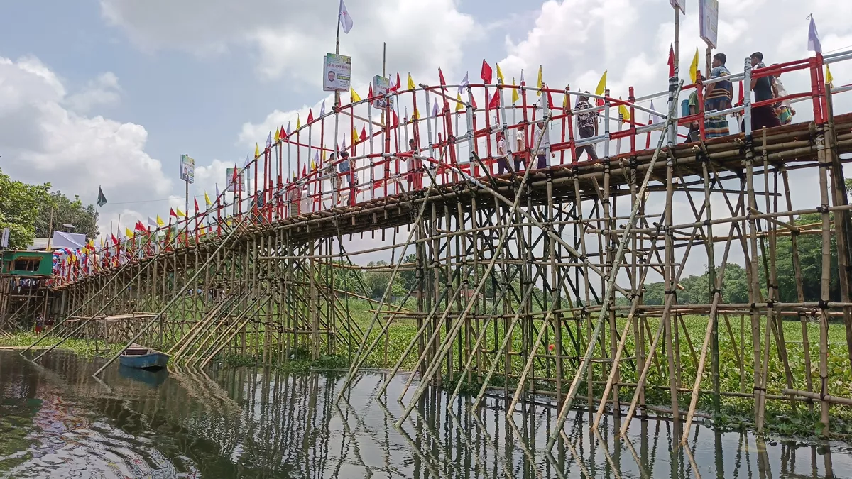 মুক্তিযোদ্ধা শামসুল হক ফাউন্ডেশনের নিজস্ব অর্থায়নে ধলেশ্বরী নদীর ওপর নির্মিত হয়েছে প্রায় ২৪০ ফুট দীর্ঘ ও ৭ ফুট প্রশস্ত বাঁশ ও কাঠের একটি সেতু। ছবি: প্রতিদিনের বাংলাদেশ  