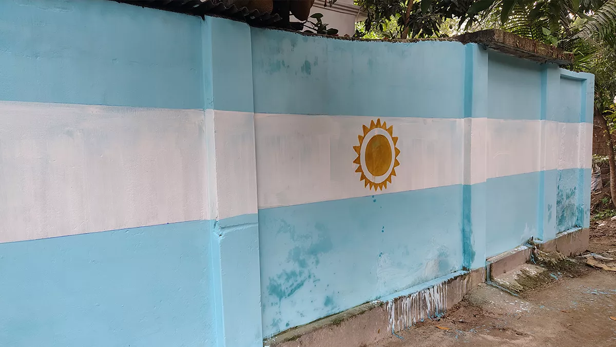 ফরিদপুরের মধুখালী পৌরসদরের বাসিন্দা সাম্মী আর্জেন্টিনার জাতীয় পতাকাকে কেন্দ্র করে নীল ও সাদা রঙের সমন্বয়ে বাড়ির দেওয়ালে রঙ করেছেন। ছবি: প্রতিদিনের বাংলাদেশ