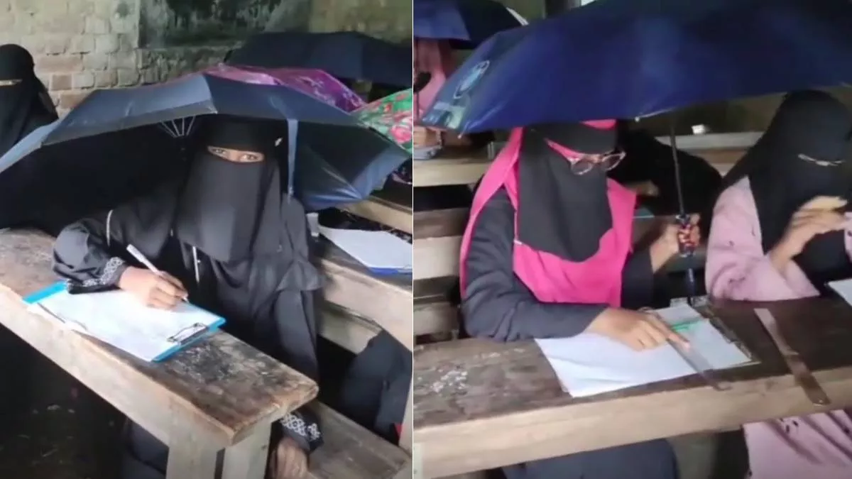 কয়েকজন ছাত্রী এক হাতে ছাতা ধরে এবং অন্য হাতে দিয়ে লিখছেন। ছবি: ভিডিও থেকে
