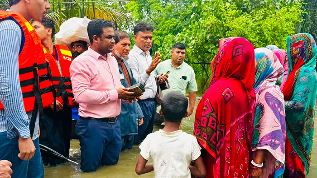 জলাবদ্ধতা উপেক্ষা করে ত্রাণ নিয়ে পানিবন্দী মানুষের কাছে যান সন্দ্বীপ উপজেলা নির্বাহী কর্মকর্তা (ইউএনও) আমজাদ হোসেন। ছবি: প্রতিদিনের বাংলাদেশ